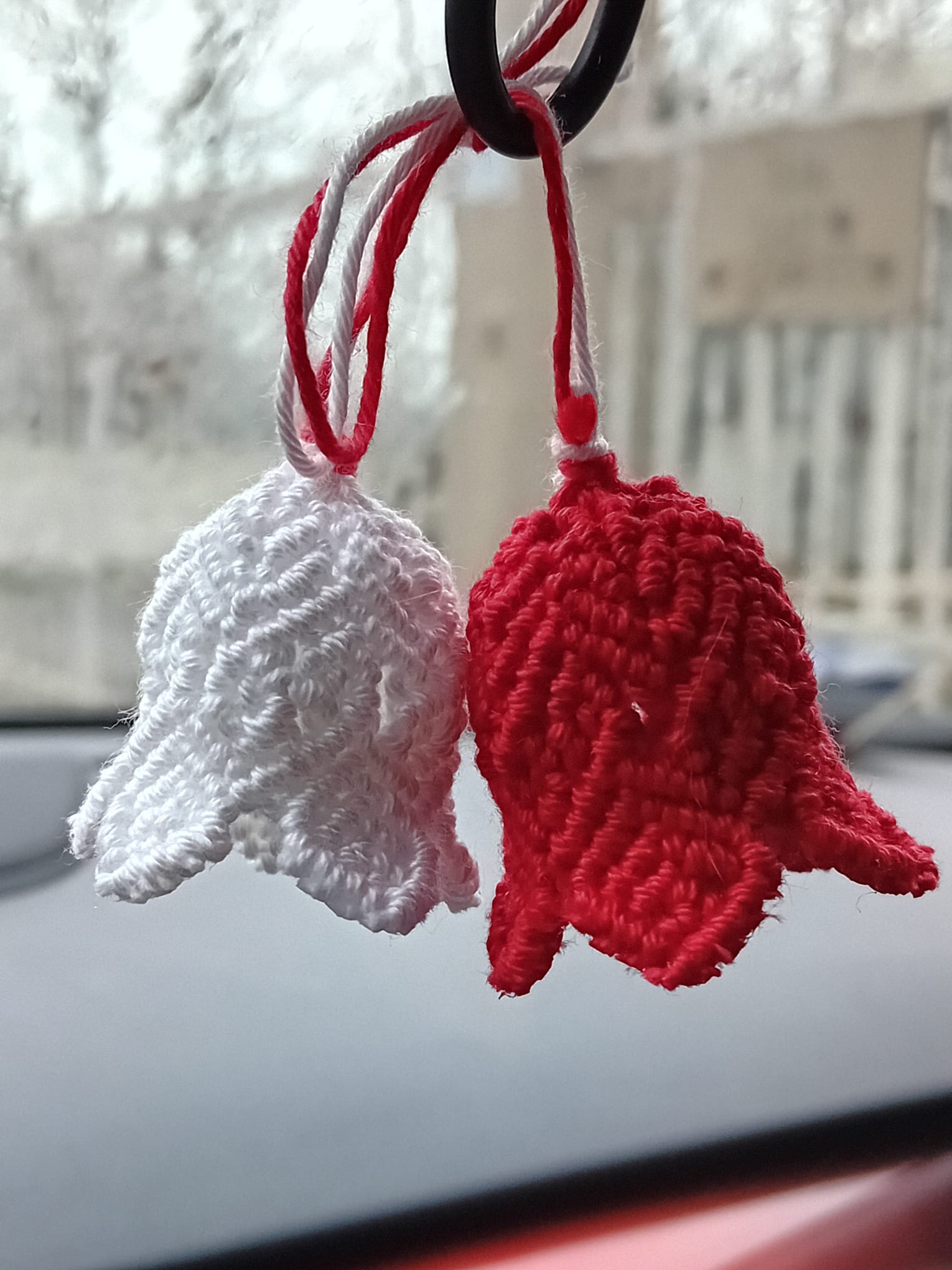 un lavoretto a macrame con delle campanelle una bianca e una rossa